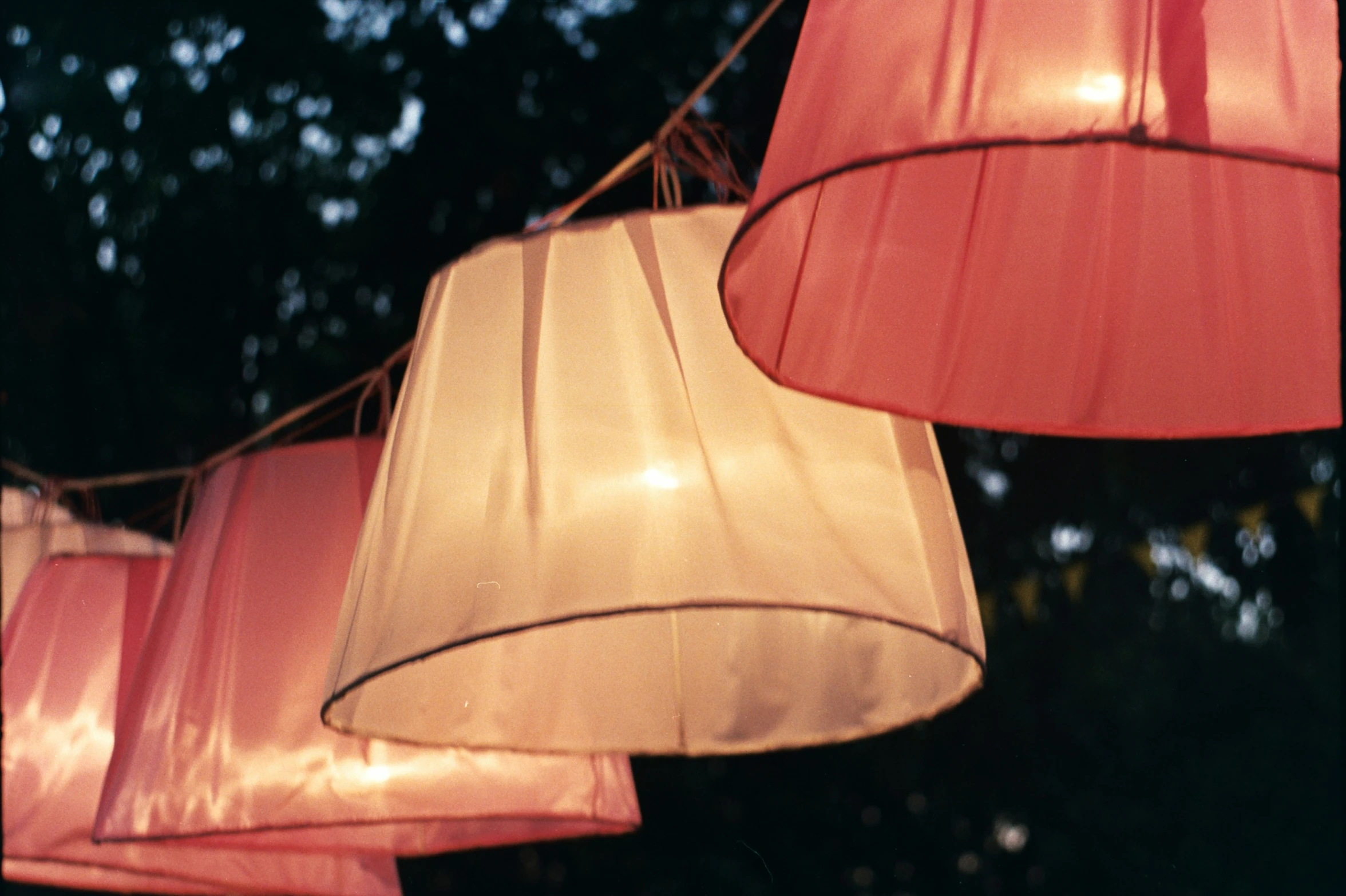 many red and beige lamps hanging from a tree