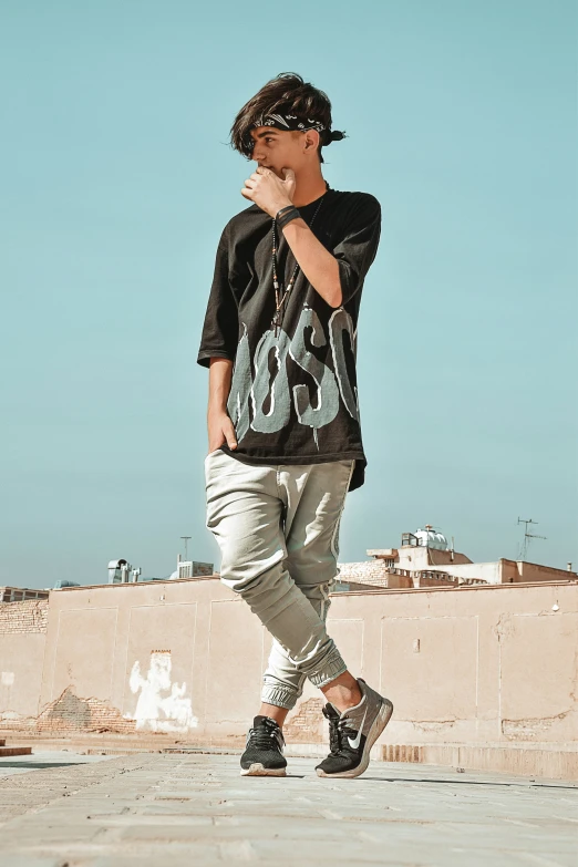 a young man standing outside by himself on a skateboard