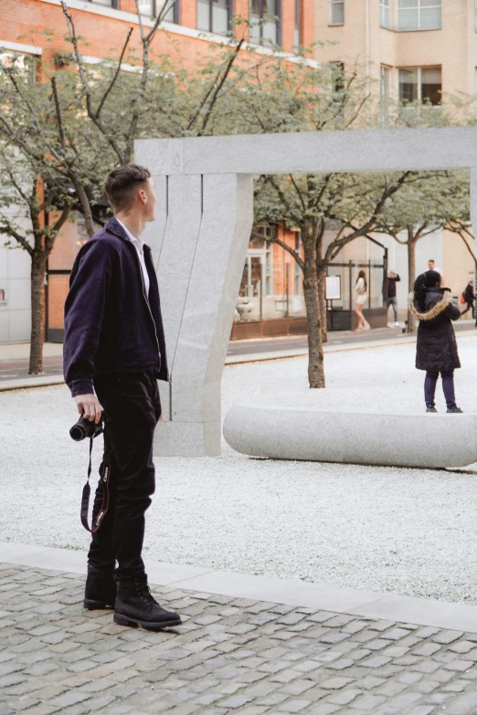 two people in black jackets near a white sculpture