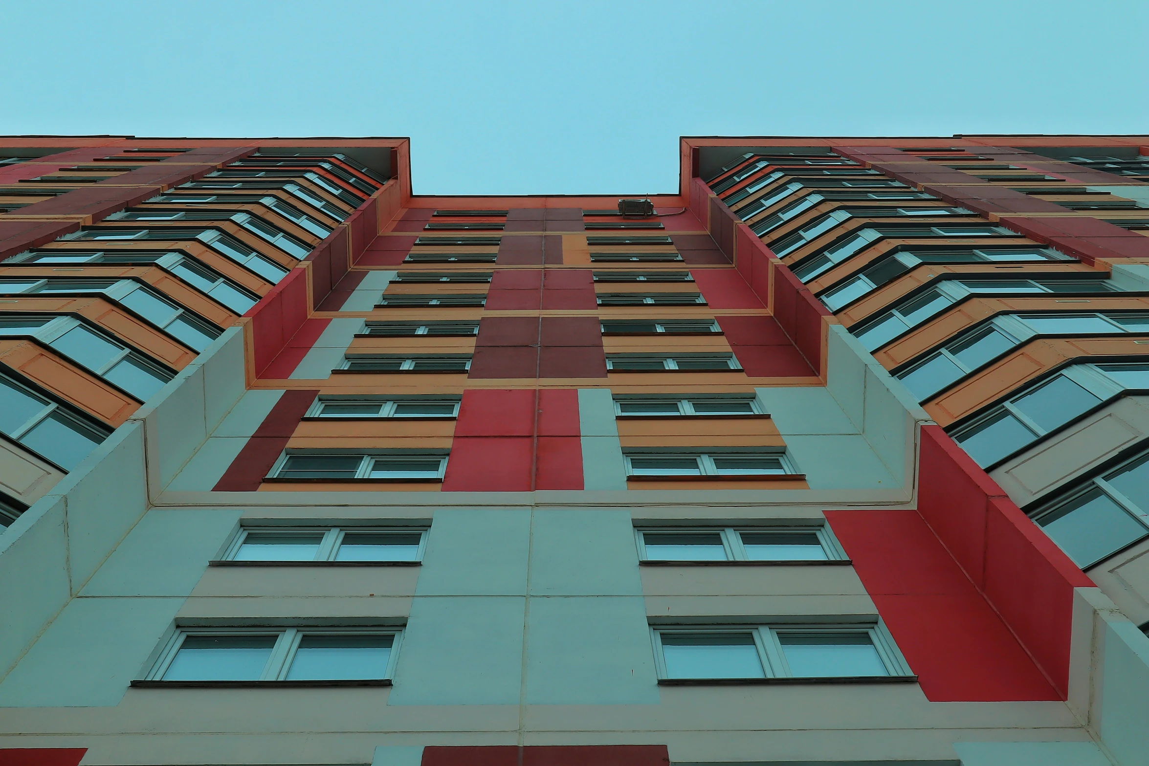 this is a very tall building with red and green windows