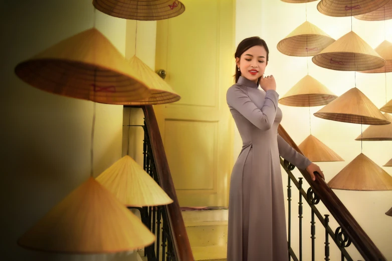 a woman standing next to a railing near a group of lights