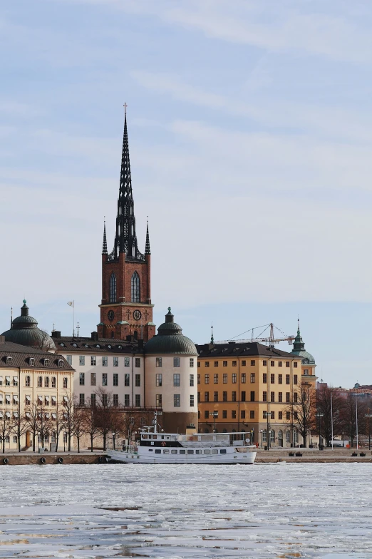 view of old buildings with a church tower next to the water