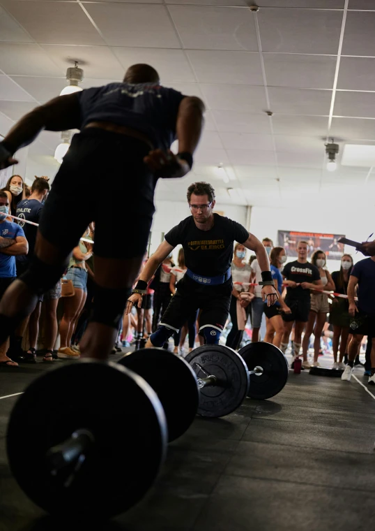 two men doing a squat competition while people watch