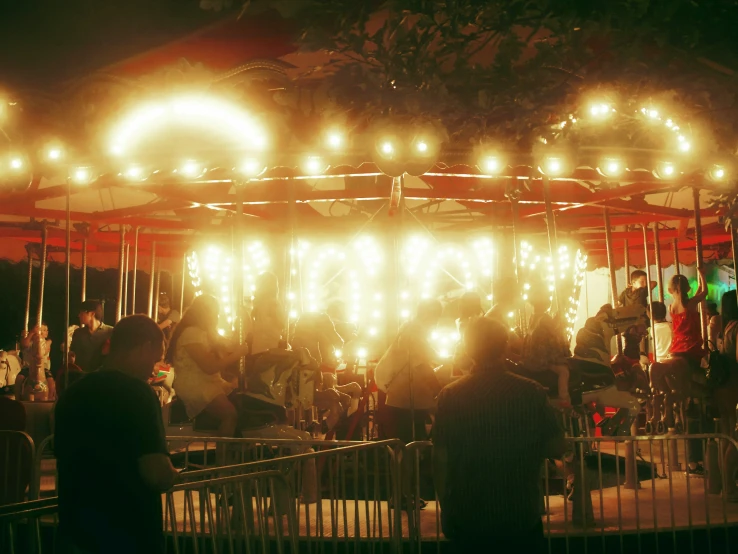 the people are on the carnival ride at night