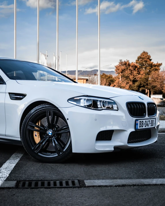 the white bmw is parked on the side of the street