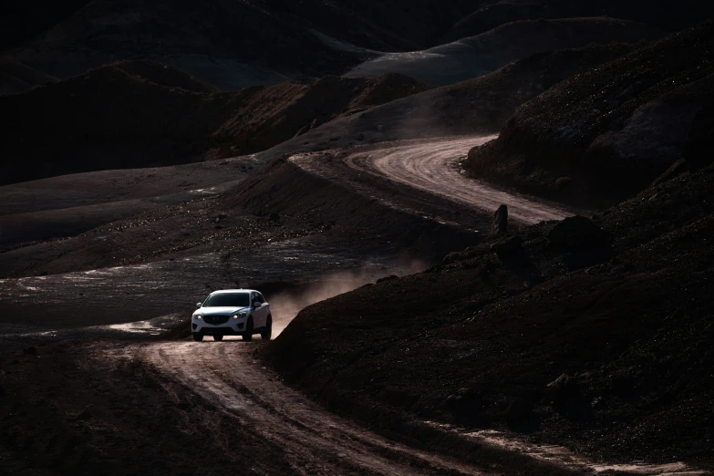 car driving down hill with dark sky