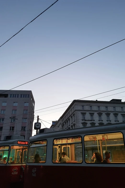 a train driving down a street near buildings