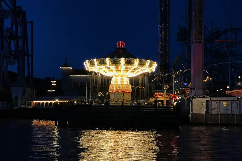 a christmas carousel on the river next to buildings