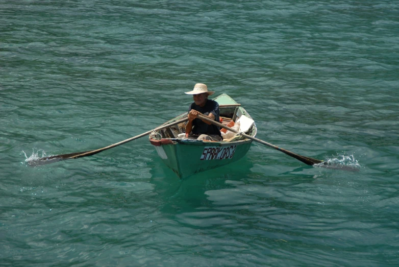 a man rows his small boat in the ocean
