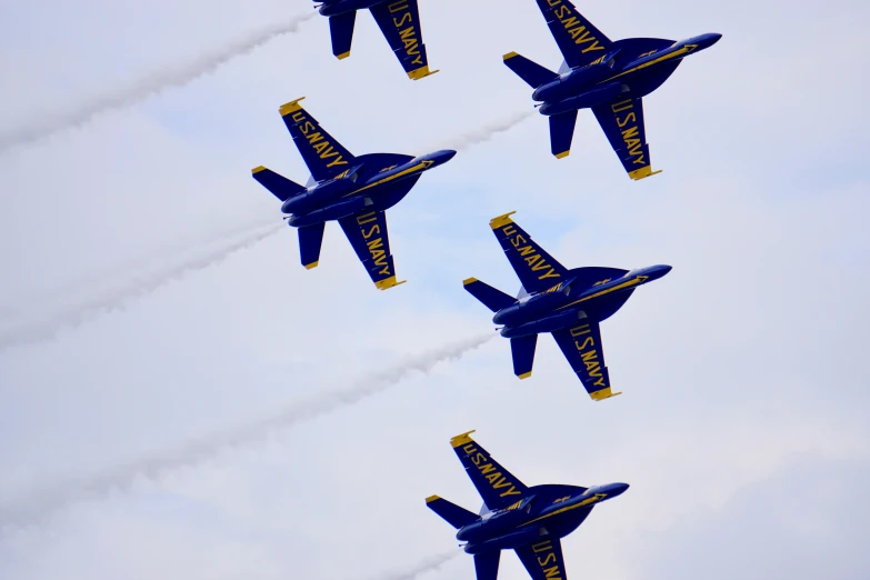 five jets are flying in the sky leaving contrails behind them