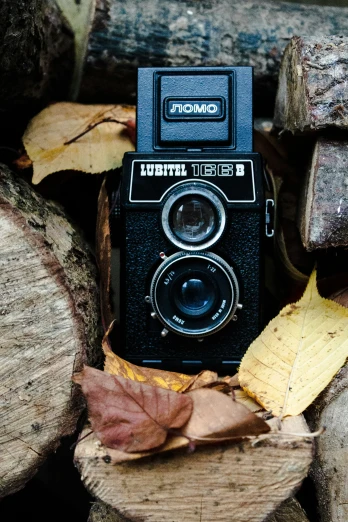 a black po camera sitting on top of wooden logs