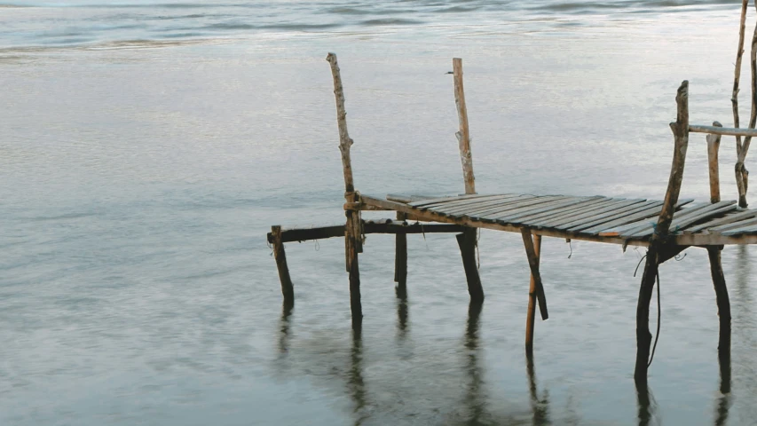 wooden dock sitting in the shallow water