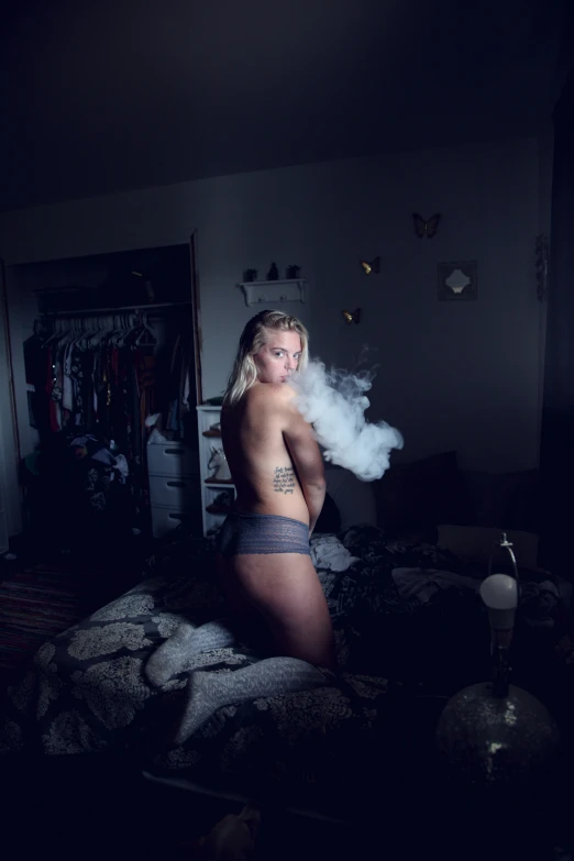 a  woman standing on a bed and smoking