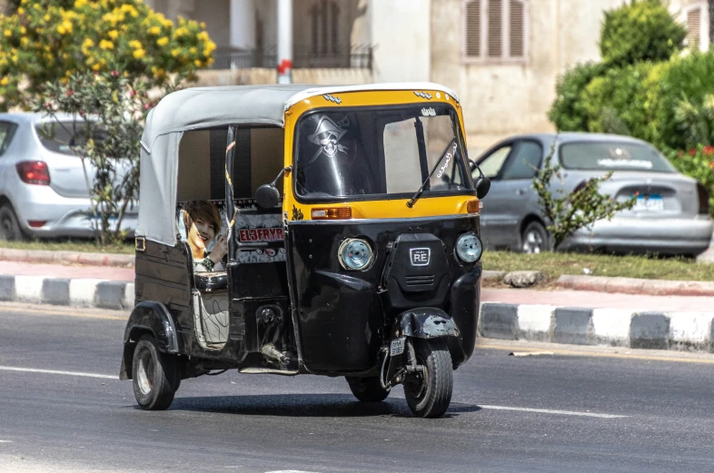 a black and yellow passenger tuk with its flatbed down