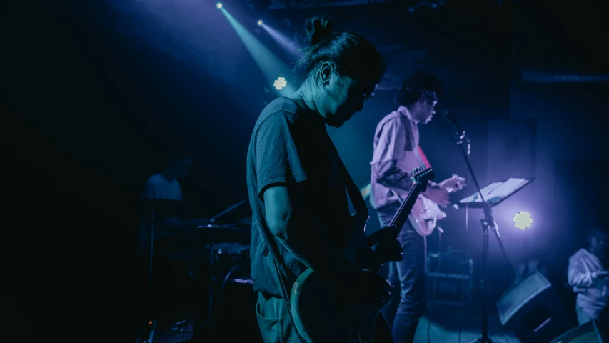 two people on a stage and one of them playing an instrument