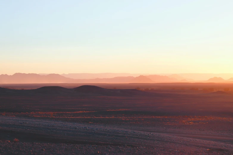 the sun rises on some distant, arid mountain range