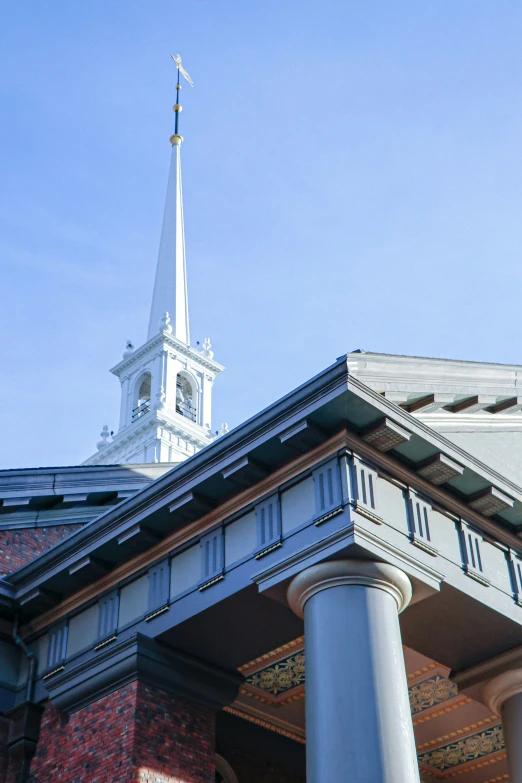 the top of a building with pillars and a clock tower on top