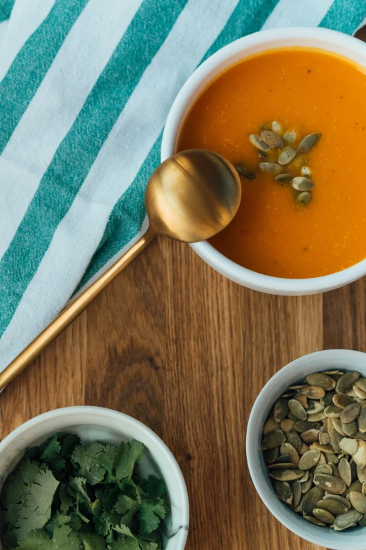 two bowls of soup next to a spoon and spoon