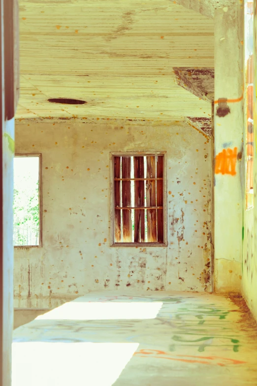 an empty room with a window and a rusted wall