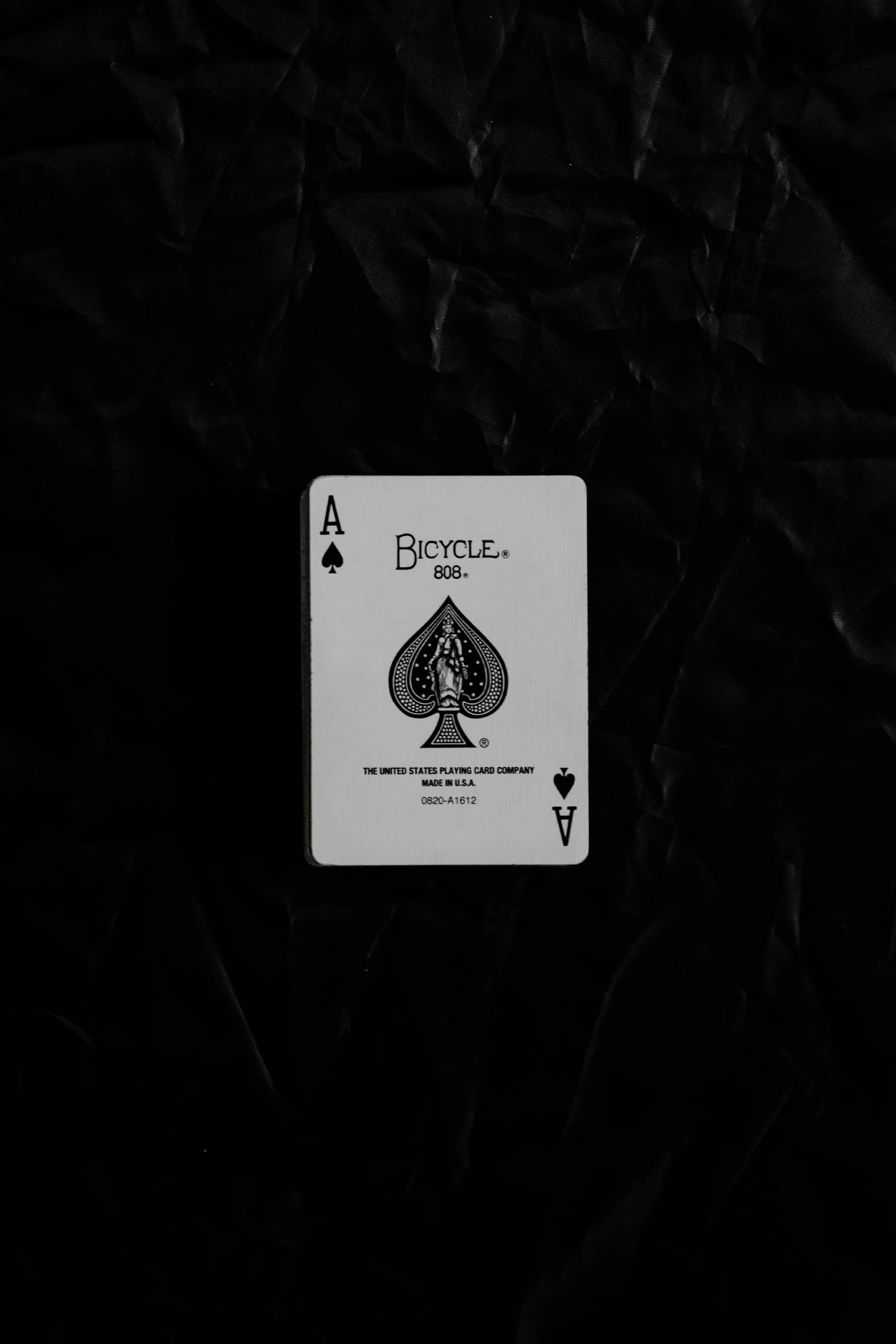 a black and white playing card that is made up of poker chips