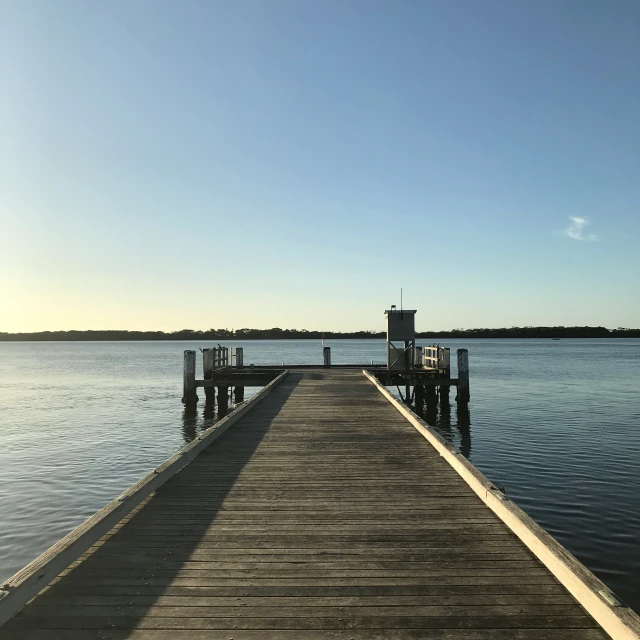 a dock sits next to the water during the day