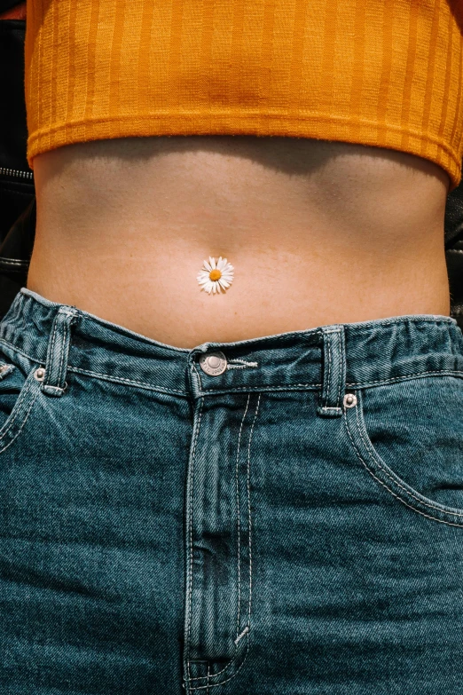 the bottom of a woman's stomach has a daisy flower on it