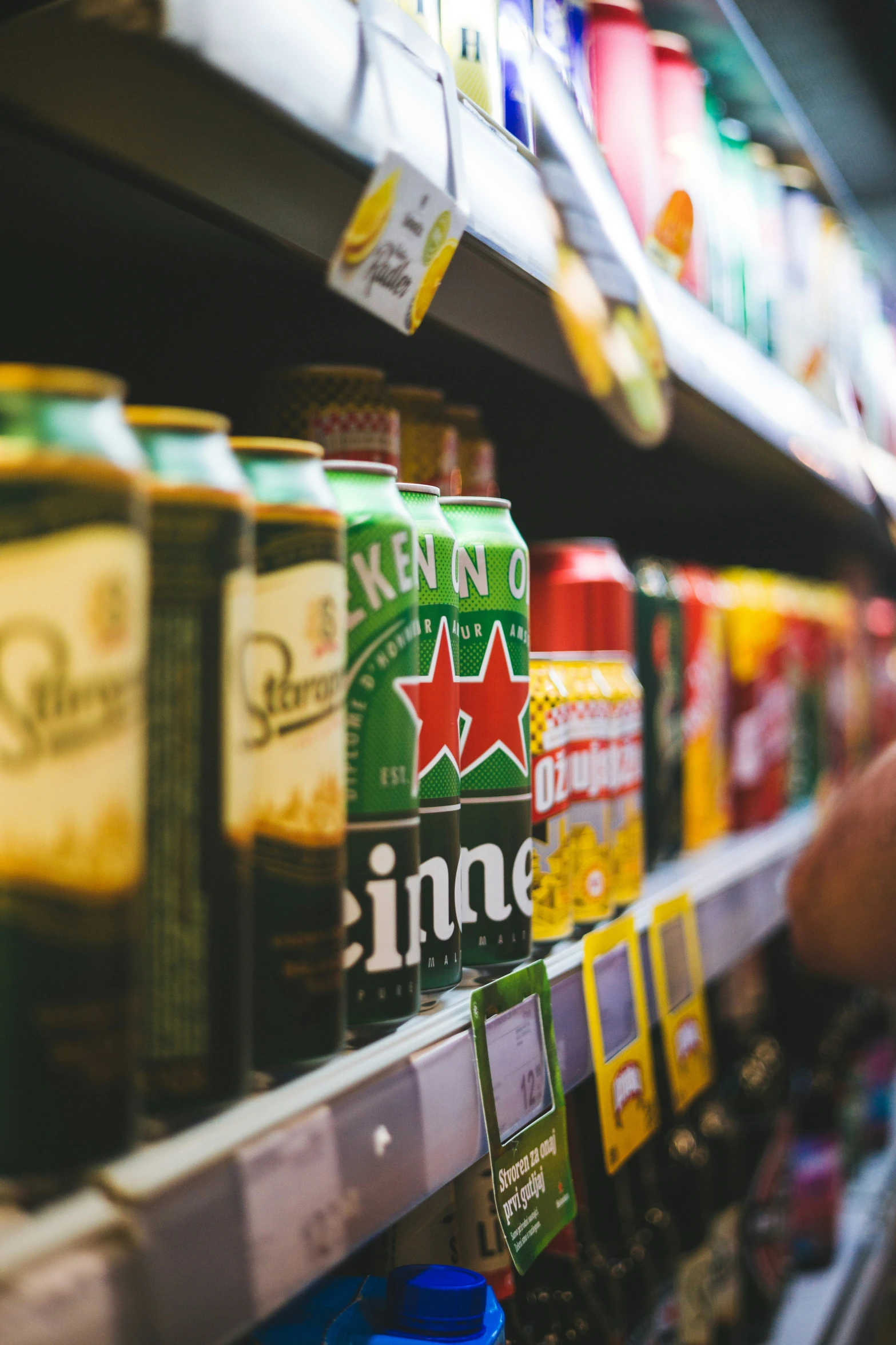 someone reaching out to grab cans of soda in a store