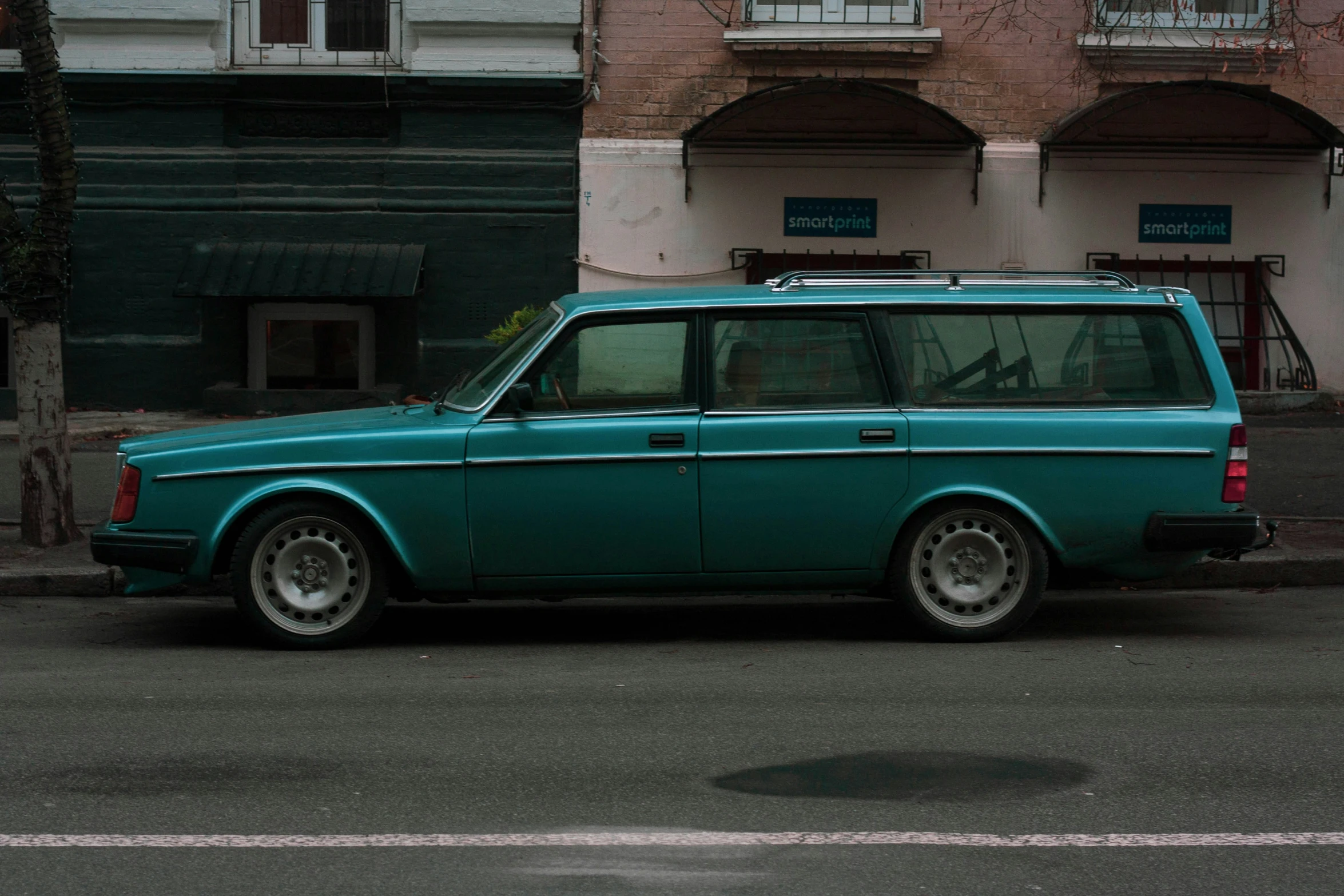 a blue car that is sitting on the side of the street