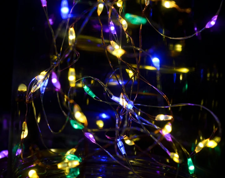 a pile of green, purple and yellow lights are against a black background
