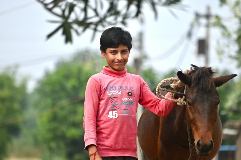 a  is standing by a small horse