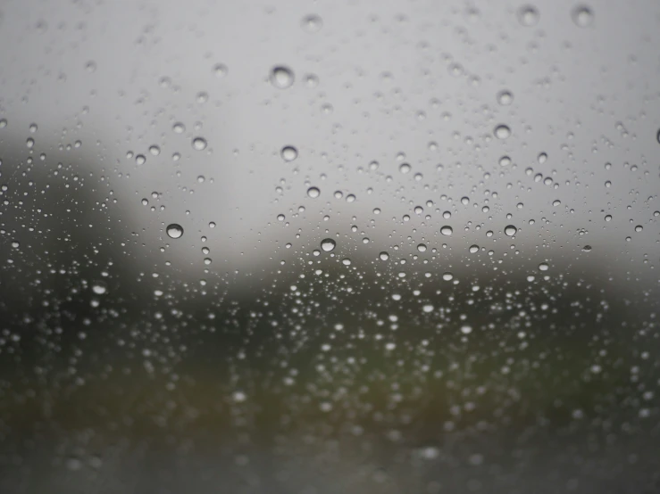 a window covered in rain with little drops of water