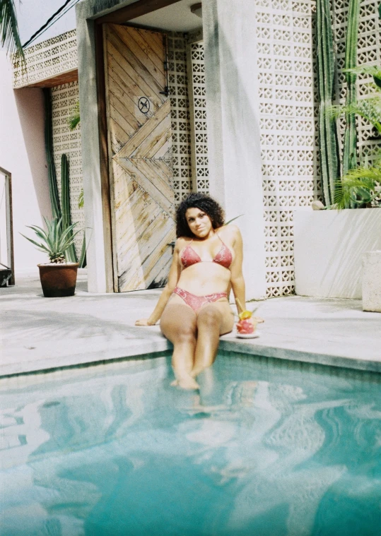 a girl in a bikini standing in a pool