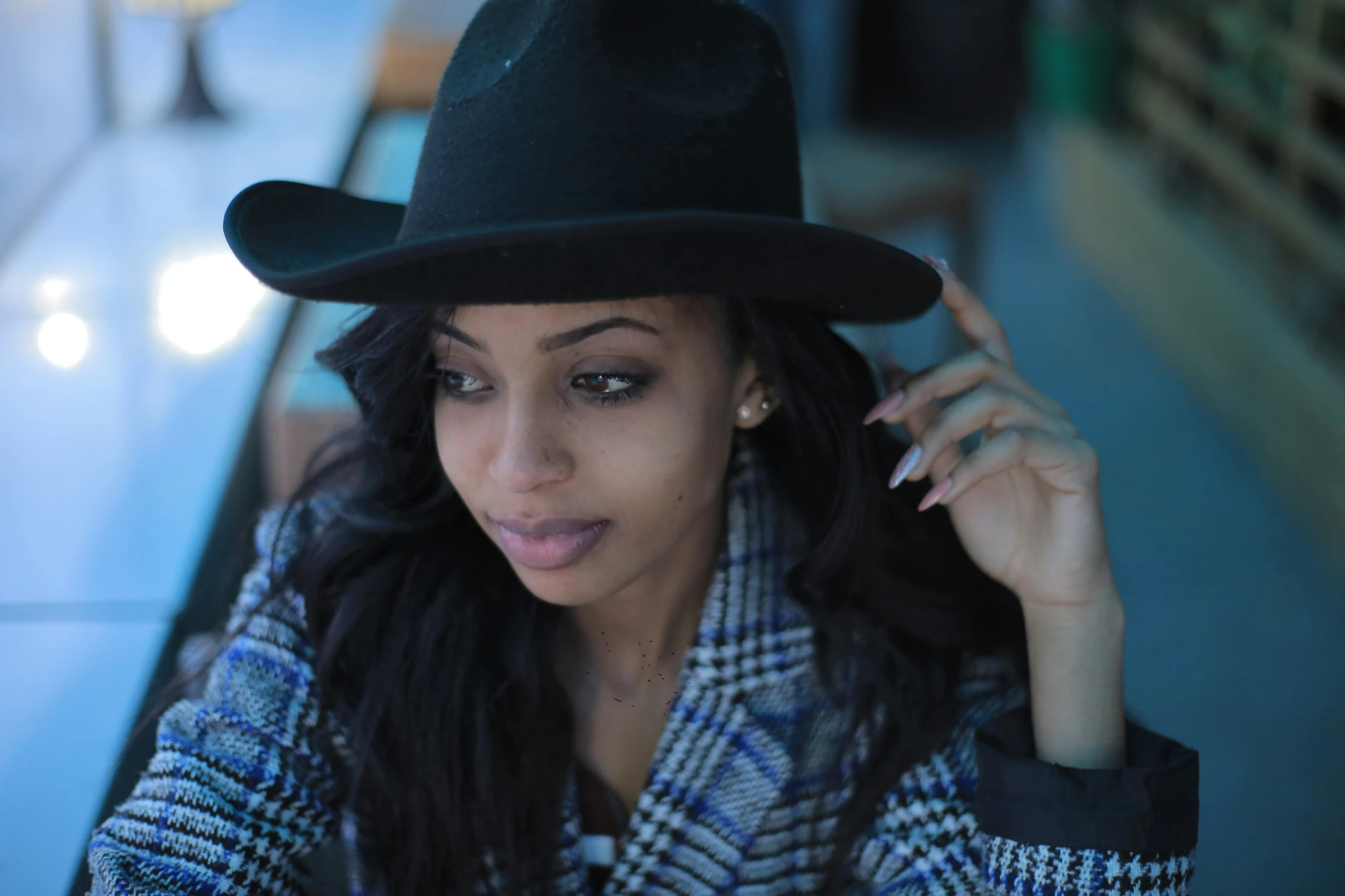 a woman is posing while wearing a black hat