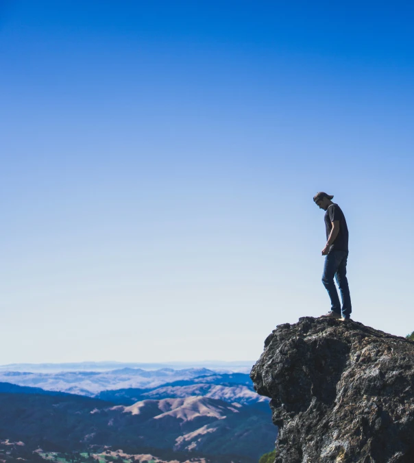 a man standing on a rock looking at the landscape