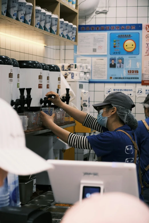 a woman wearing glasses using a machine in a coffee shop