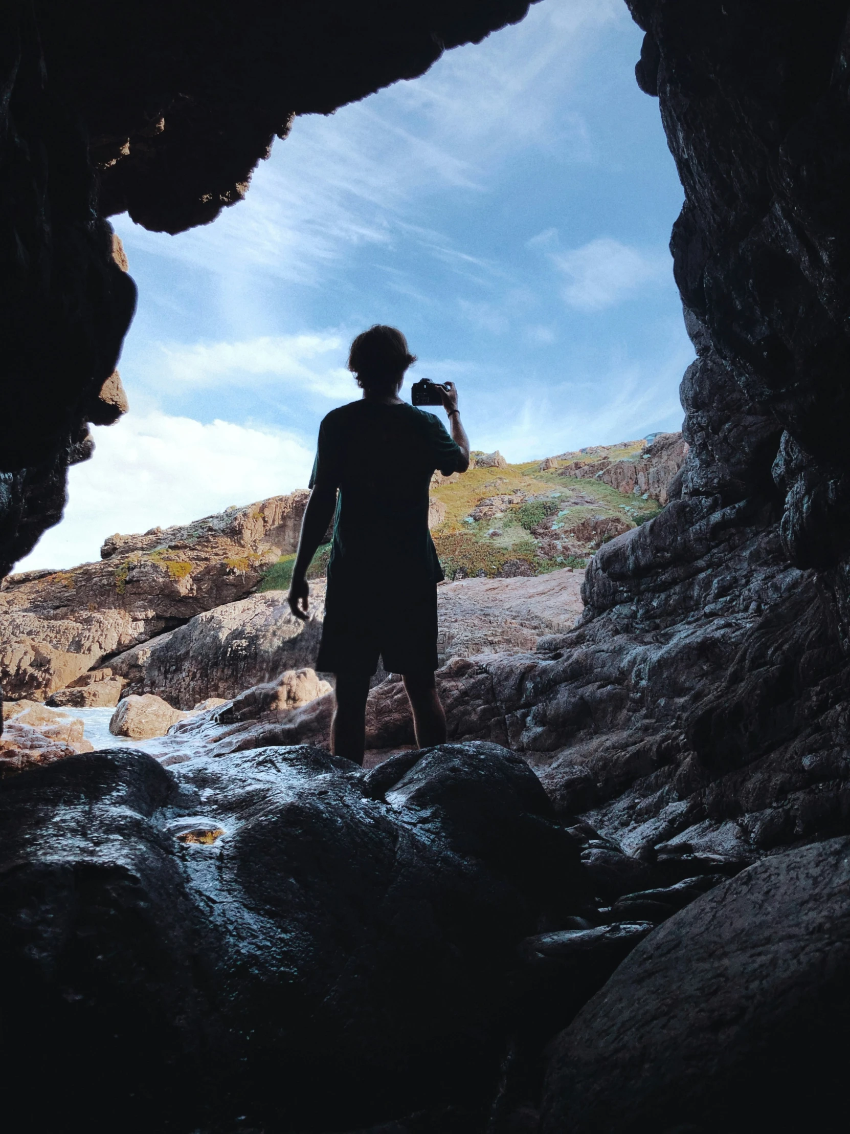 a man standing in a cave while taking his picture