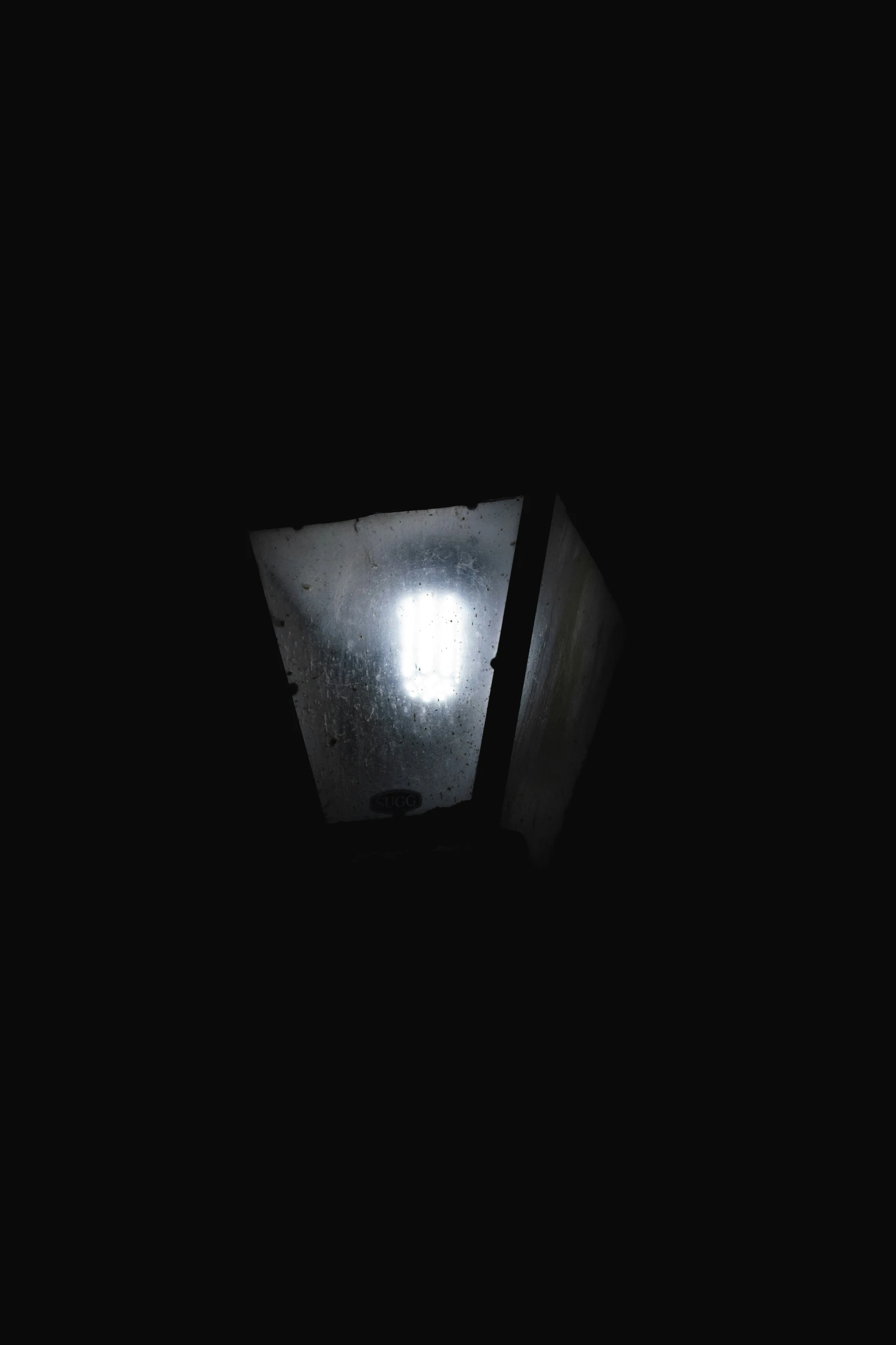 a window in a dark room with a light coming through