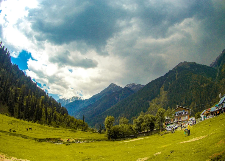 the mountains are very steep with people standing in a field