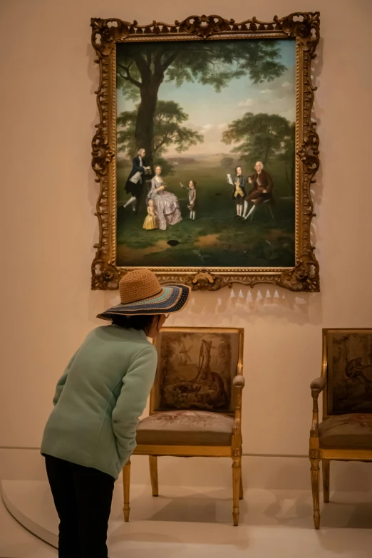 woman in front of an ornate painting showing people playing golf