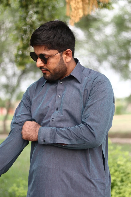 man in shirt and jeans leaning on hand