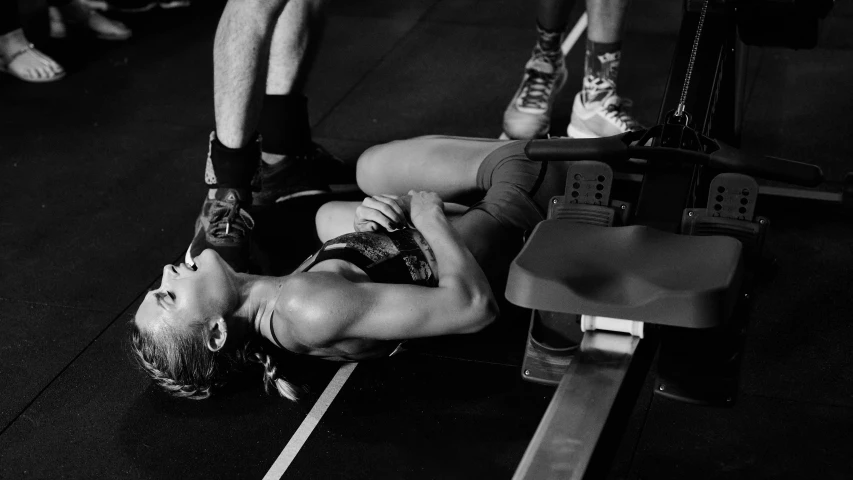 a person laying on the floor in front of a barbell