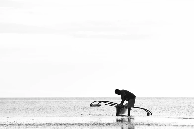 a man is standing on a beach with his surfboard