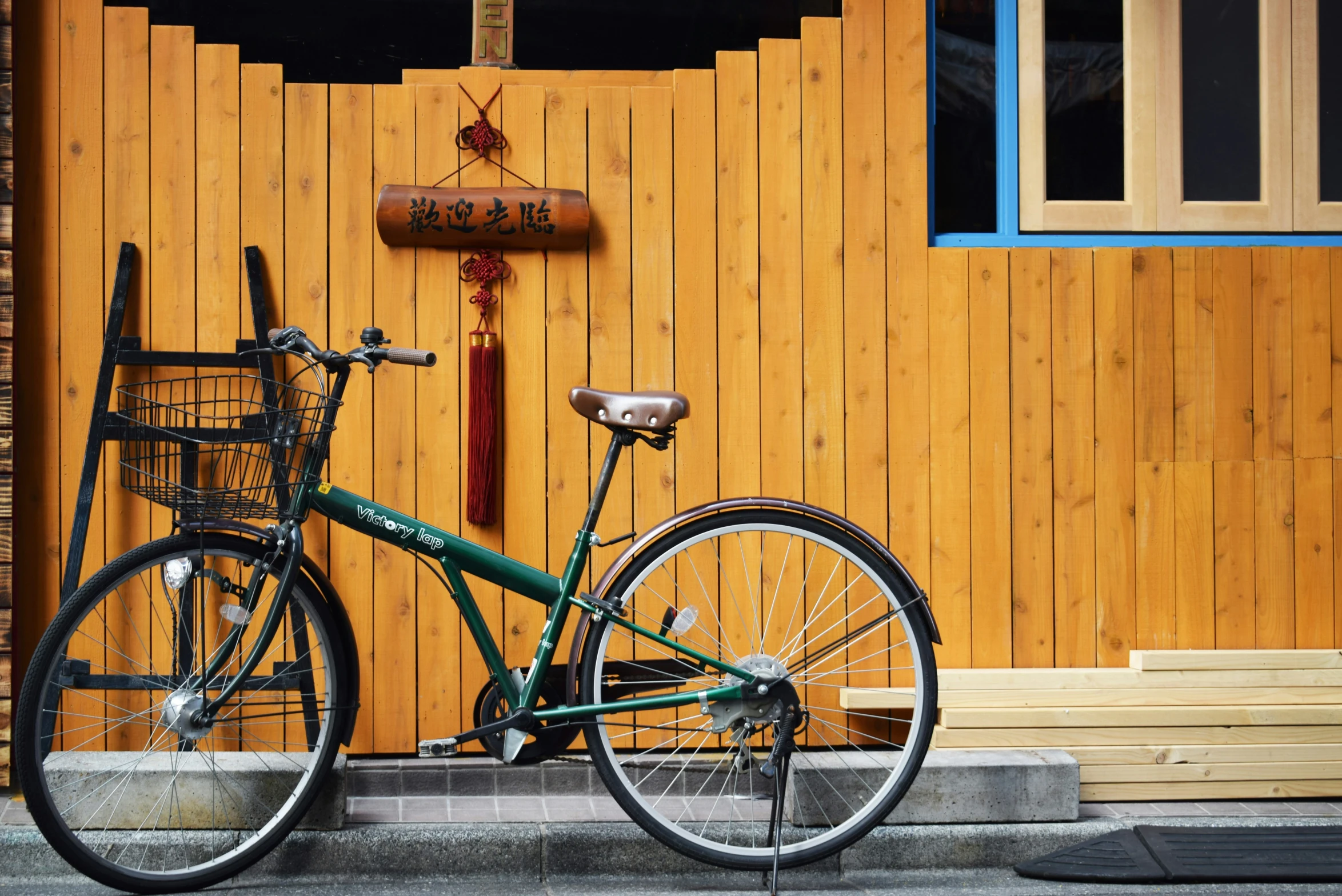 a green bicycle sits in front of an open door