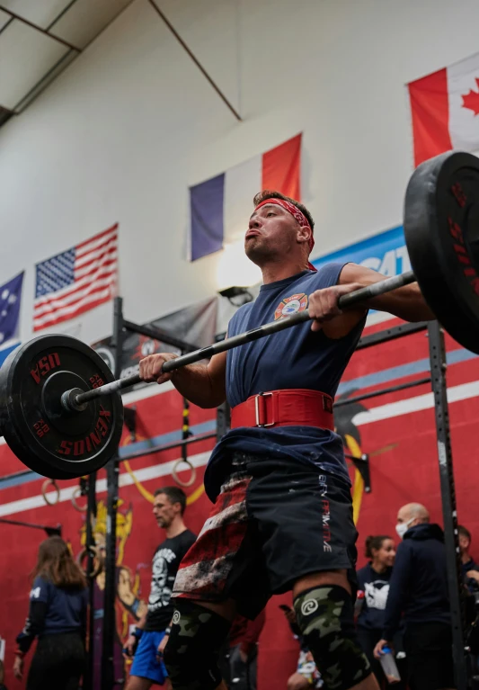 a man doing a squat with a barbell in a gym