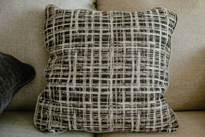 a black and white pillow on the back of a couch