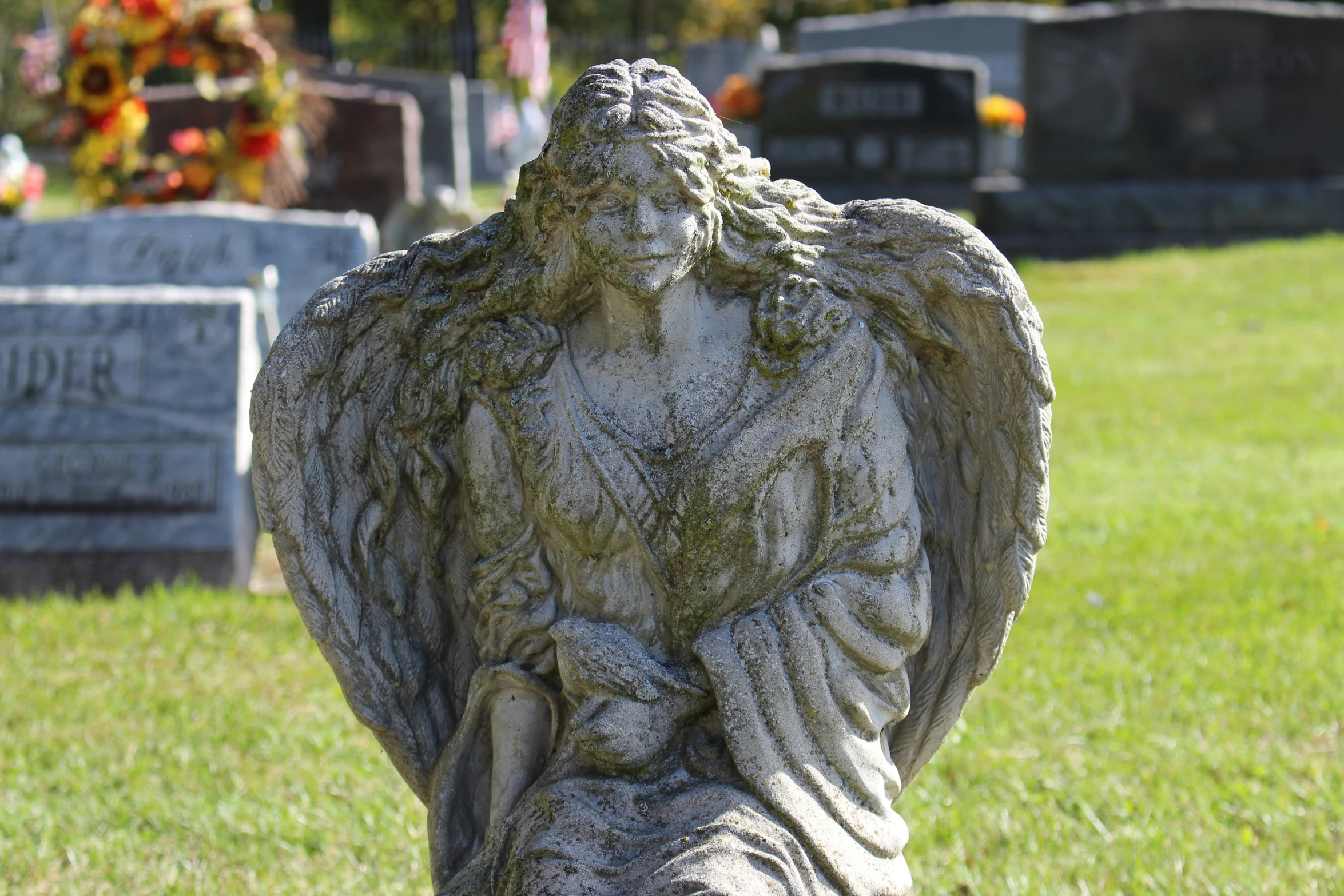 a statue in the shape of an angel standing on a grave