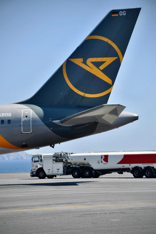 large plane parked on tarmac with truck nearby