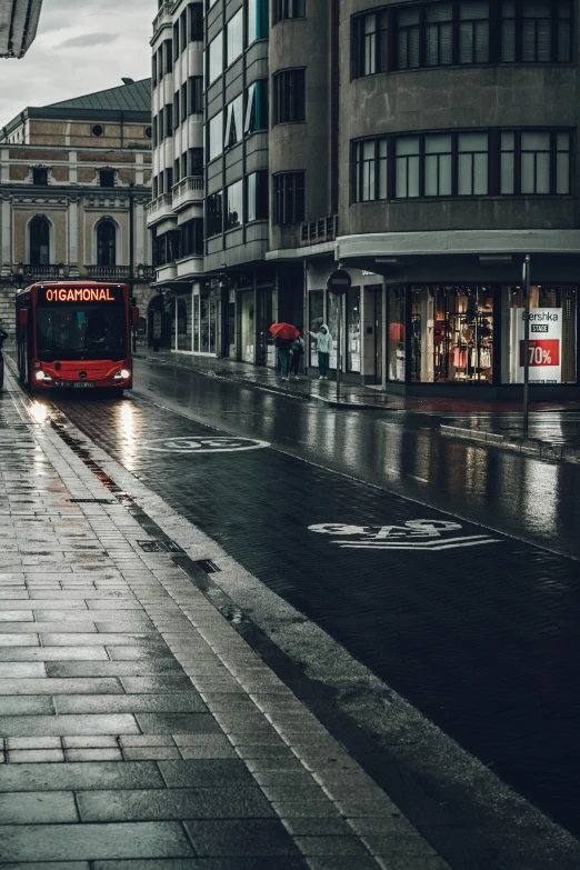 two buses are driving on the street in the rain