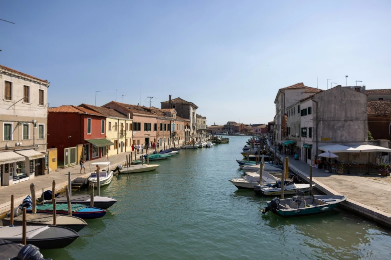 a canal is seen filled with boats and buildings