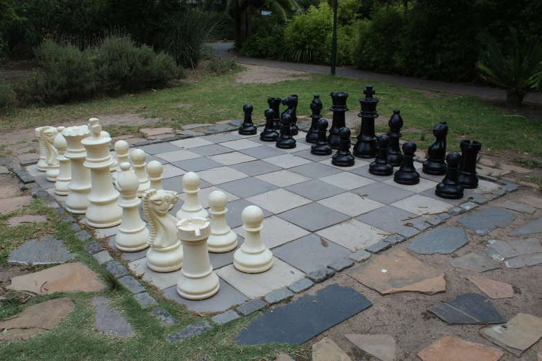 a chess board is set up outside on the grass